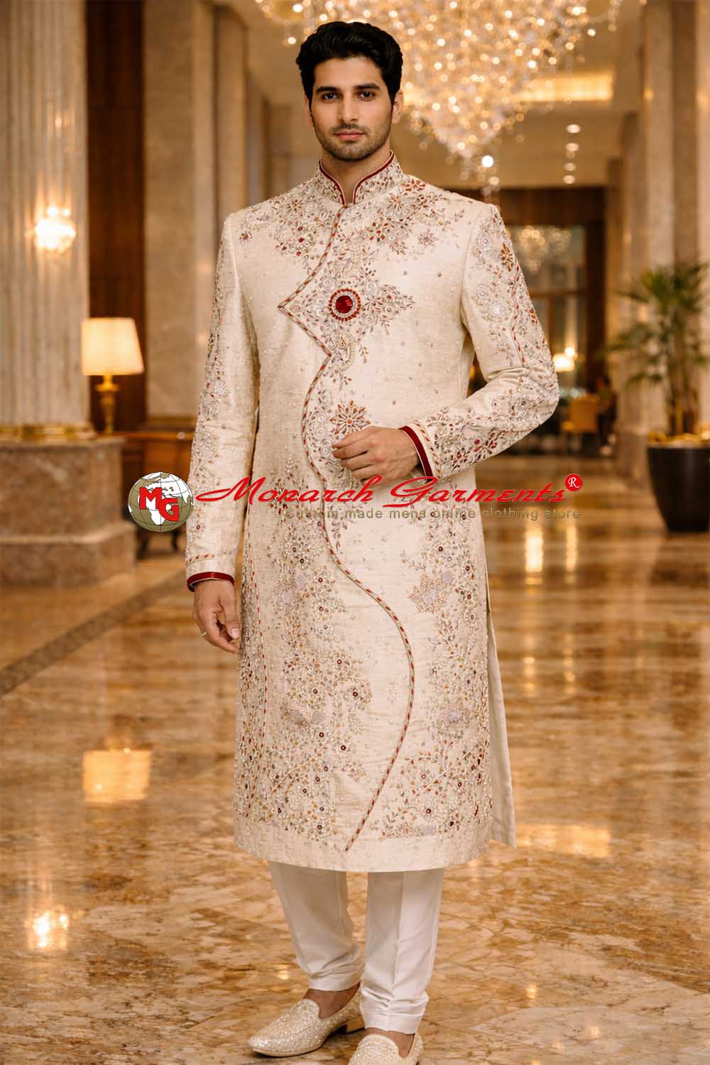 Indian groom wearing ivory brocade embroidered wedding sherwani with red threadwork by Monarch Garments